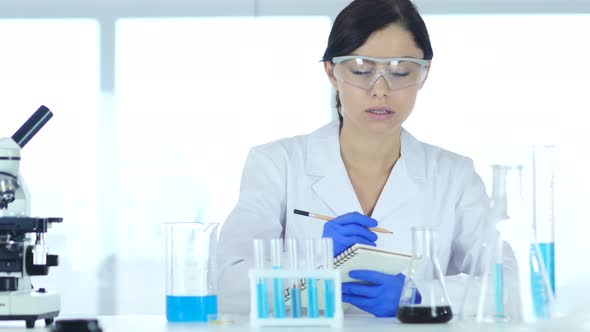 Scientist Writing Details, Result of Research in Laboratory