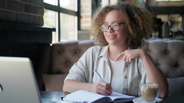 Online Teaching, Female Student Is Remotely Trained By Video Call on Laptop Sitting at Table