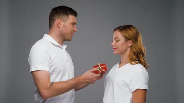 Happy Man Giving Little Red Present To Woman