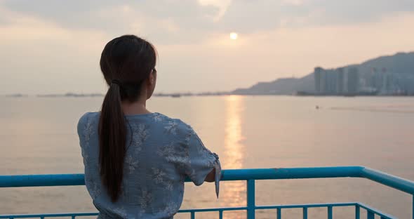 Woman look around the sea view at sunset