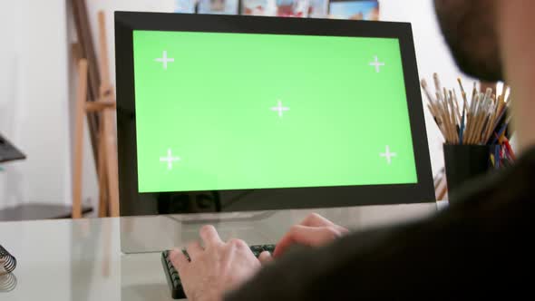 Man Types Continuously in Front of a Green Screen