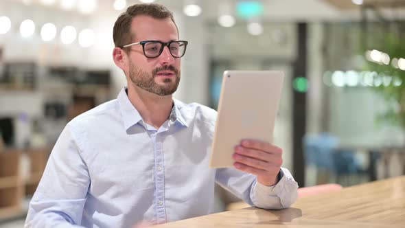 Businessman Doing Video Call on Tablet in Office