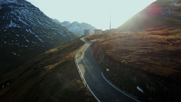 Road Cyclist Climbs Up Sunset Mountain Switchbacks