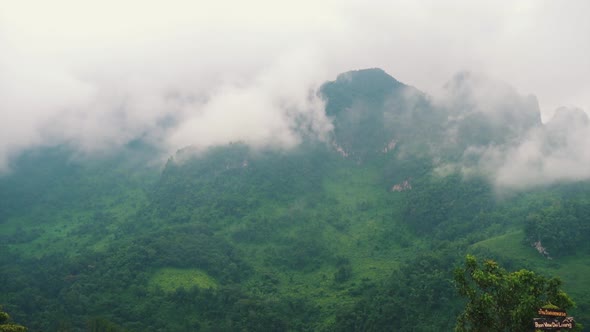 Real time lapse of lush green mountains with moving clouds