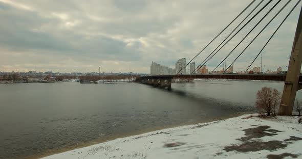 Winter City Bridge Aerial View. Skyline Kiev City In December. Drone Landscape Dnieper River.