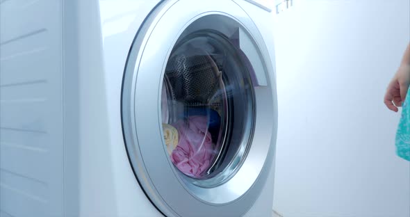 Close Up Industrial Washing Machine Washes Colored Clothing and White Linen, White Striped Clothing