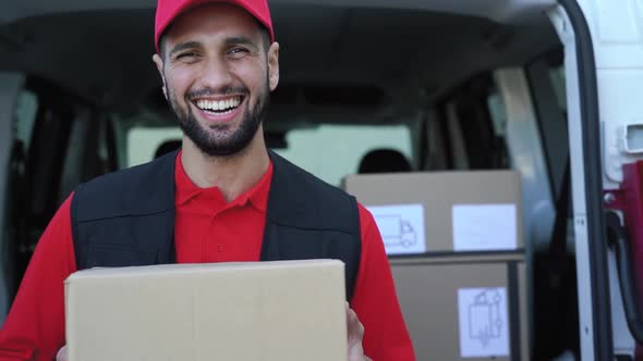 Young delivery man carrying cardboard box - People working with fast deliver transportation