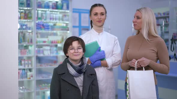 Portrait of Confident Young Beautiful Woman Posing with Clients in Drugstore Indoors