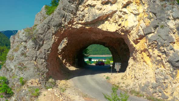 Road and tunnel at Piva Lake in national park Dormitor of Montenegro at summer