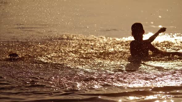 Kids playing in the evening water background. Two friends having fun together in the river