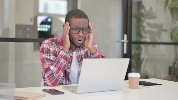 African Man Reacting to Loss While Using Laptop