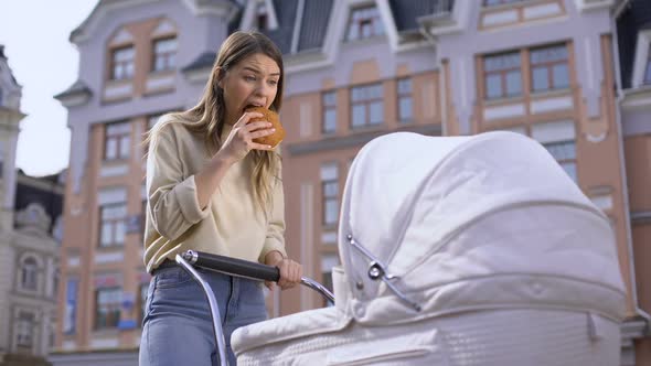 Nervous Busy Mom Swinging Infant in Pram and Chewing Bun, Having Snack in Park