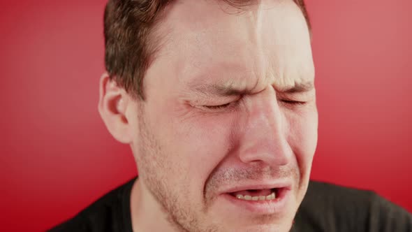 Portrait of a Crying Man on a Red Background