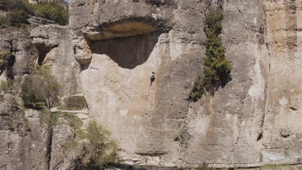 Drone view of a man climbing on a rock in Cuenca, Spain