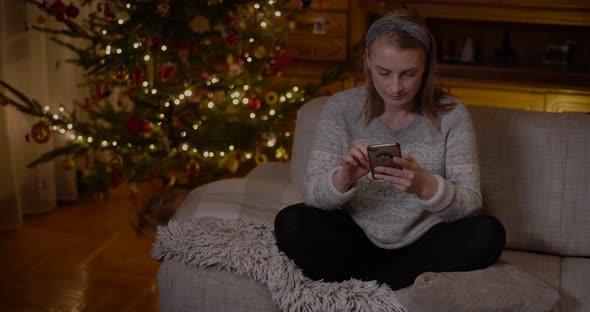 Woman Browsing Social Media on Smartphone at Home