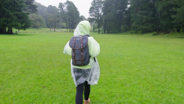 Happy Carefree Female Hiker Walking Under Pouring Tropical Rain By Green Forest