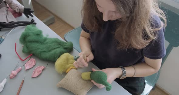 Woman Making Wool Art Doll Toy at Table. Female Sitting and Creating Ooak Doll at Home. Needle