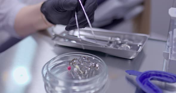 Medic Takes a Drill with Tweezers From a Jar