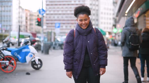 Slow motion young beautiful black woman outdoor looking camera laughing