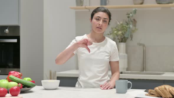 Indian Woman Showing Thumbs Down While Standing in Kitchen