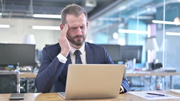 Tired Young Businessman Having Headache in Office