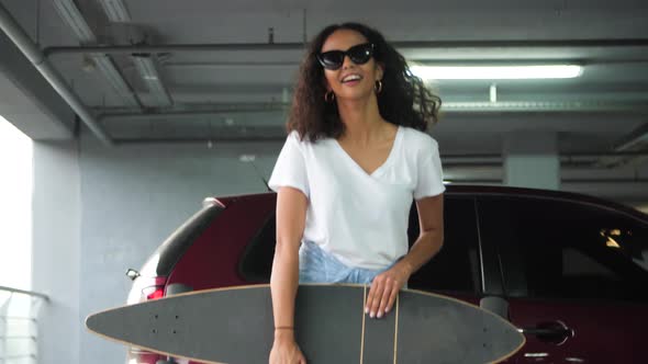 Smiling Beautiful Woman In Casual Clothes With Skateboard