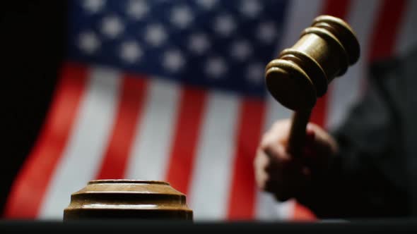 Judge Hammering With Wooden Gavel Against Waving American Flag in USA Court Room