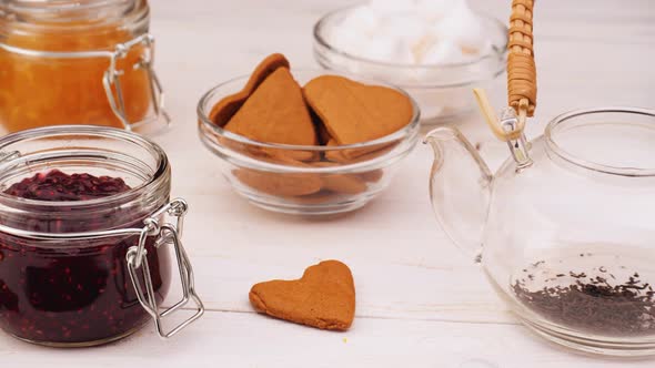 Person Brewing Tea Near Various Sweet Snacks