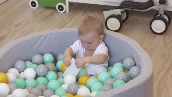 Kid Playing with Smartphone in Ball Pit at Home