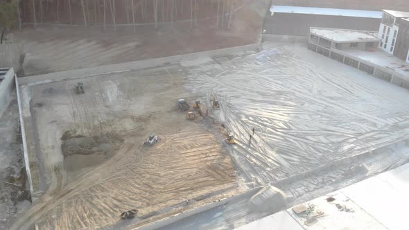 Aerial View Machinery on a Construction Site. Construction Work with the Help of Tractors and Other