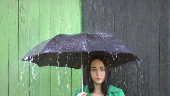 Heavy Rain pours on Girl Sheltered under Umbrella