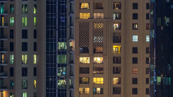 Glowing Windows in Multistory Modern Glass and Metal Residential Building Light Up at Night