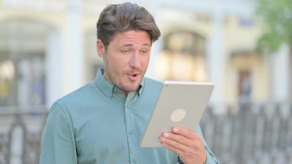 Video Call on Tablet by Middle Aged Man Outdoor