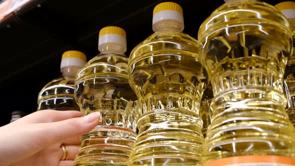 A Woman Chooses Vegetable Oil in a Supermarket