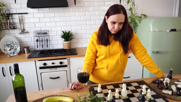 Young Man Dances Drinks Red Wine and Plays Chess in Kitchen