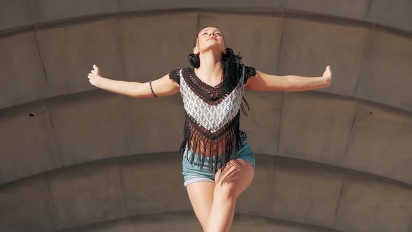 Dancing Female. happy mixed race woman dancing performance with long dreadlocks in shorts