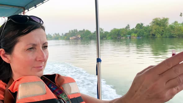 Woman on a Boat Tour Taking Images with Her Smartphone