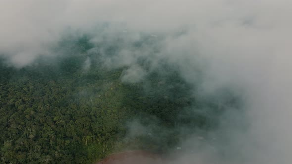 Descending flight through clouds showing treetops of jungle and Amazon River in Peru