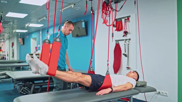 Young Man Doing Exercises Under Physiotherapist Supervision alt
