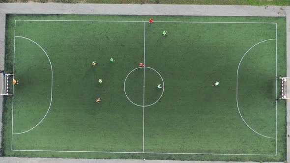 Top View of a Sports Football Field with Players Playing Football