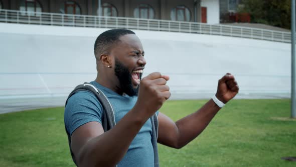 Man Celebrating Victory at Stadium, Athlete Enjoying Success on Racetrack