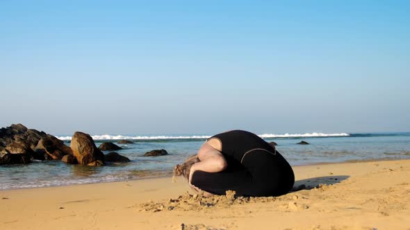 Young Woman Practices Yoga Stretching Back and Neck