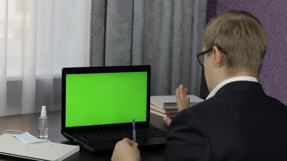 Man Have Video Call Conference on Laptop with Green Screen. Distance Work Online