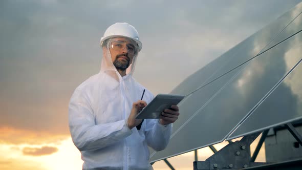 Solar Construction with a Male Energetics Engineer Working Next To It