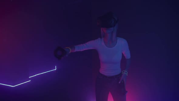 Young Happy Girl Wearing Virtual Reality Headset Holding Joystick Controllers Playing Game, Looking