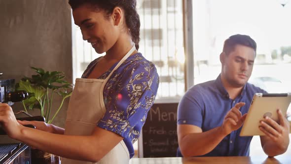 Waitress making cup of coffee in cafe