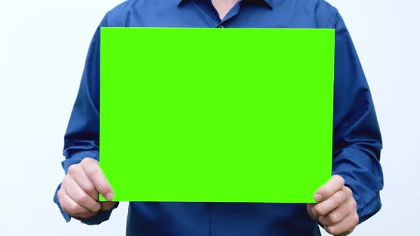 man in the hands of holds and shakes a green screen was set up