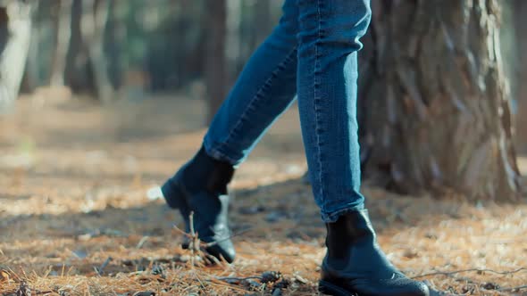 Female Feet Wearing Jeans And Shoes Walking On Road. Stylish Woman Resting Walk. Girl Legs Sneakers.