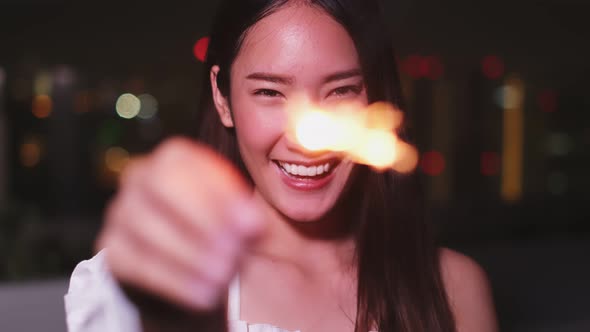 Young asian woman with sparklers is dancing and celebrating a new year. Fireworks,