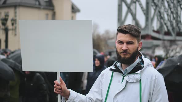 Sad Man on Funeral Holds Blank Advertising Copyspace Card Board Banner for Text